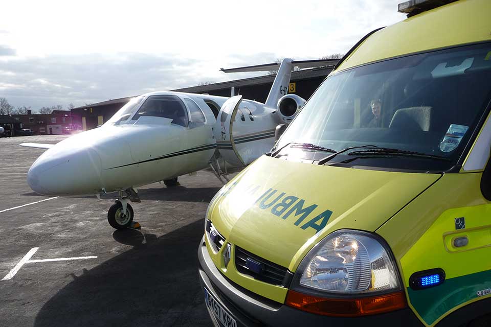 Business jet parked next to an ambulance