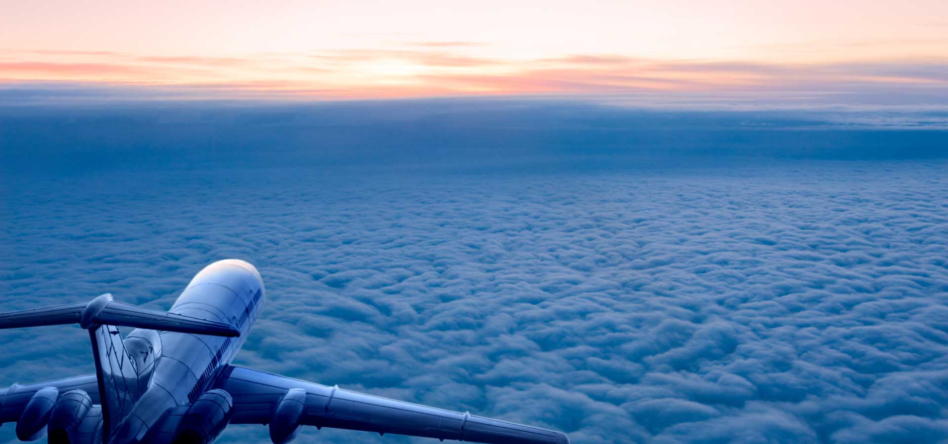Private jet above the clouds during sunrise