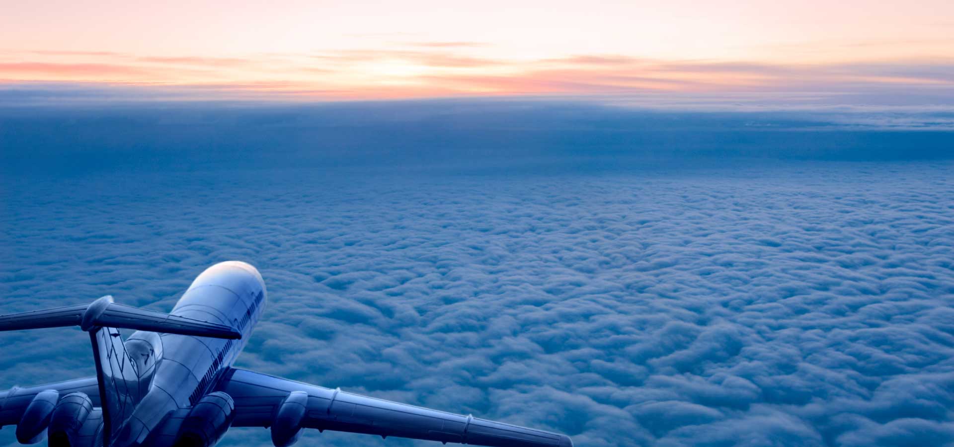 Private jet above the clouds during sunrise